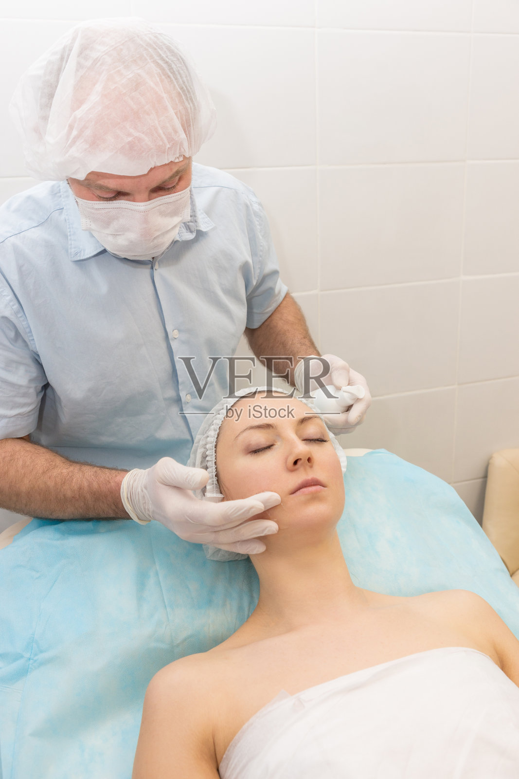 医生美容师做了一个面具的脸和拿着一罐霜在他的手照片摄影图片