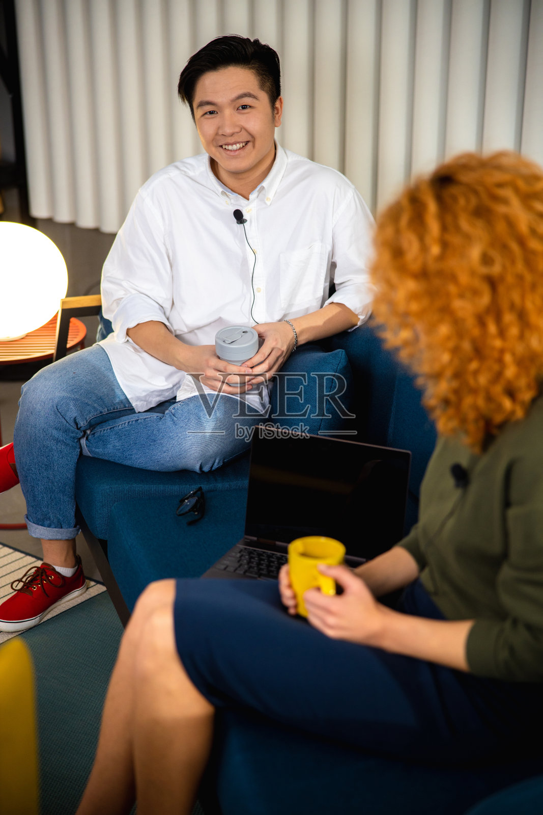 快乐的亚洲人坐在沙发上和女士聊天照片摄影图片