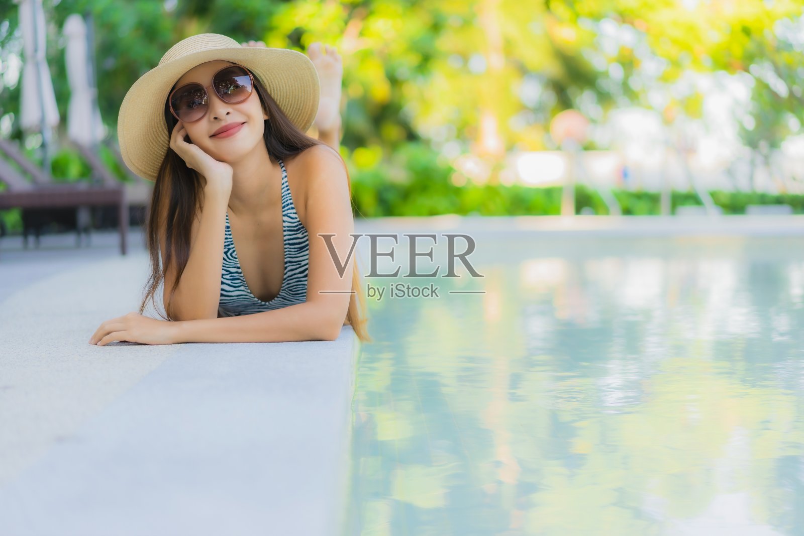 美丽的年轻亚洲女人快乐的微笑放松周围的户外游泳池在酒店度假旅游照片摄影图片