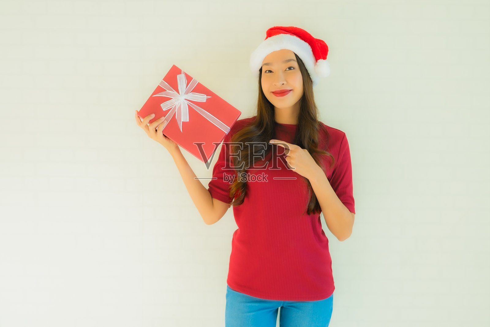 肖像美丽的年轻亚洲妇女戴圣诞帽与圣诞礼盒照片摄影图片
