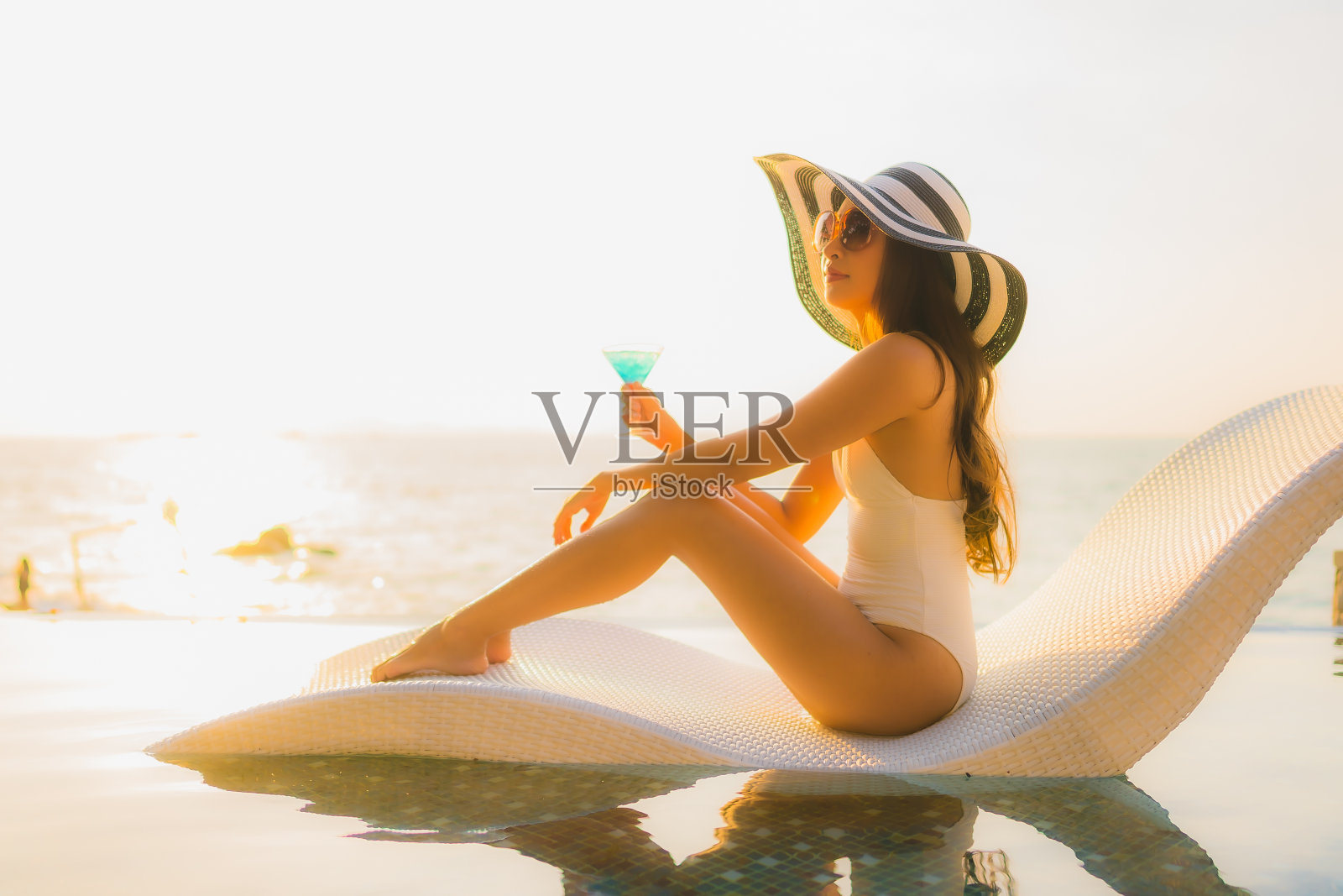 肖像美丽的年轻亚洲妇女快乐的微笑放松周围的室外游泳池照片摄影图片