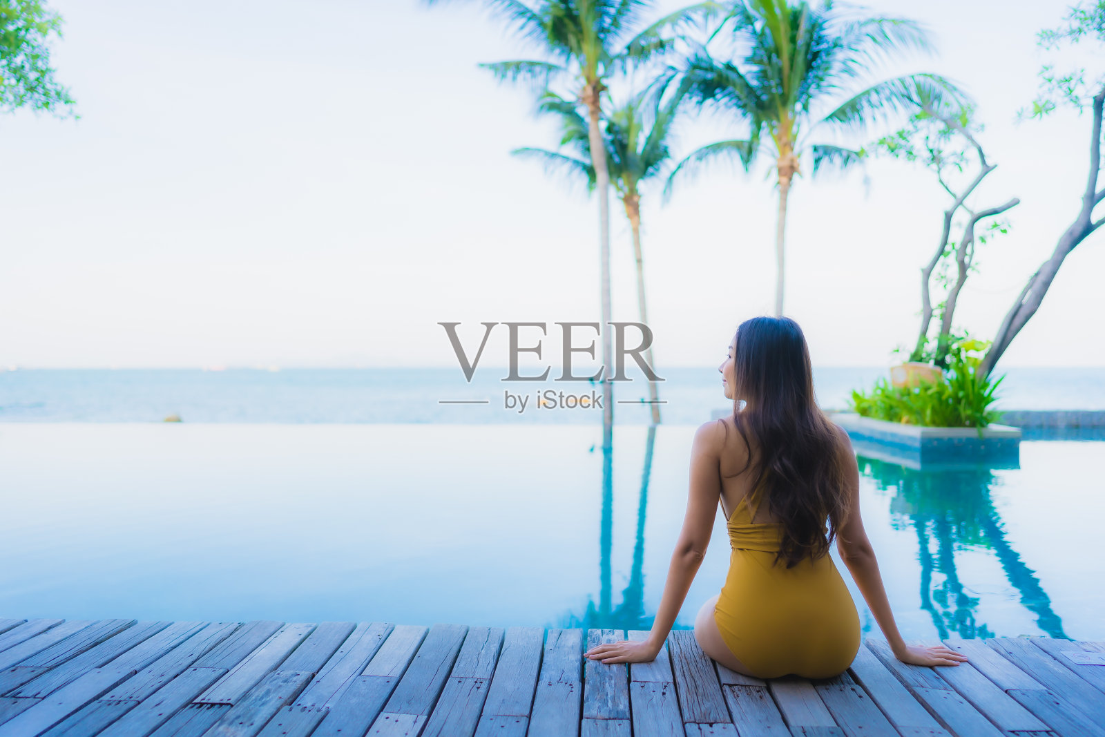 肖像美丽的年轻亚洲妇女快乐的微笑放松周围的室外游泳池照片摄影图片