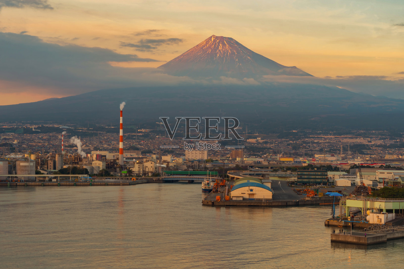 日本静冈市日落时富士山附近工业区、工厂、日本港口和港口的鸟瞰图。自然景观背景。照片摄影图片