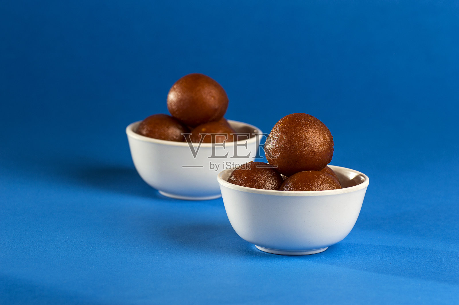 印度甜点:在碗里,勺子在蓝色的背景上照片摄影图片