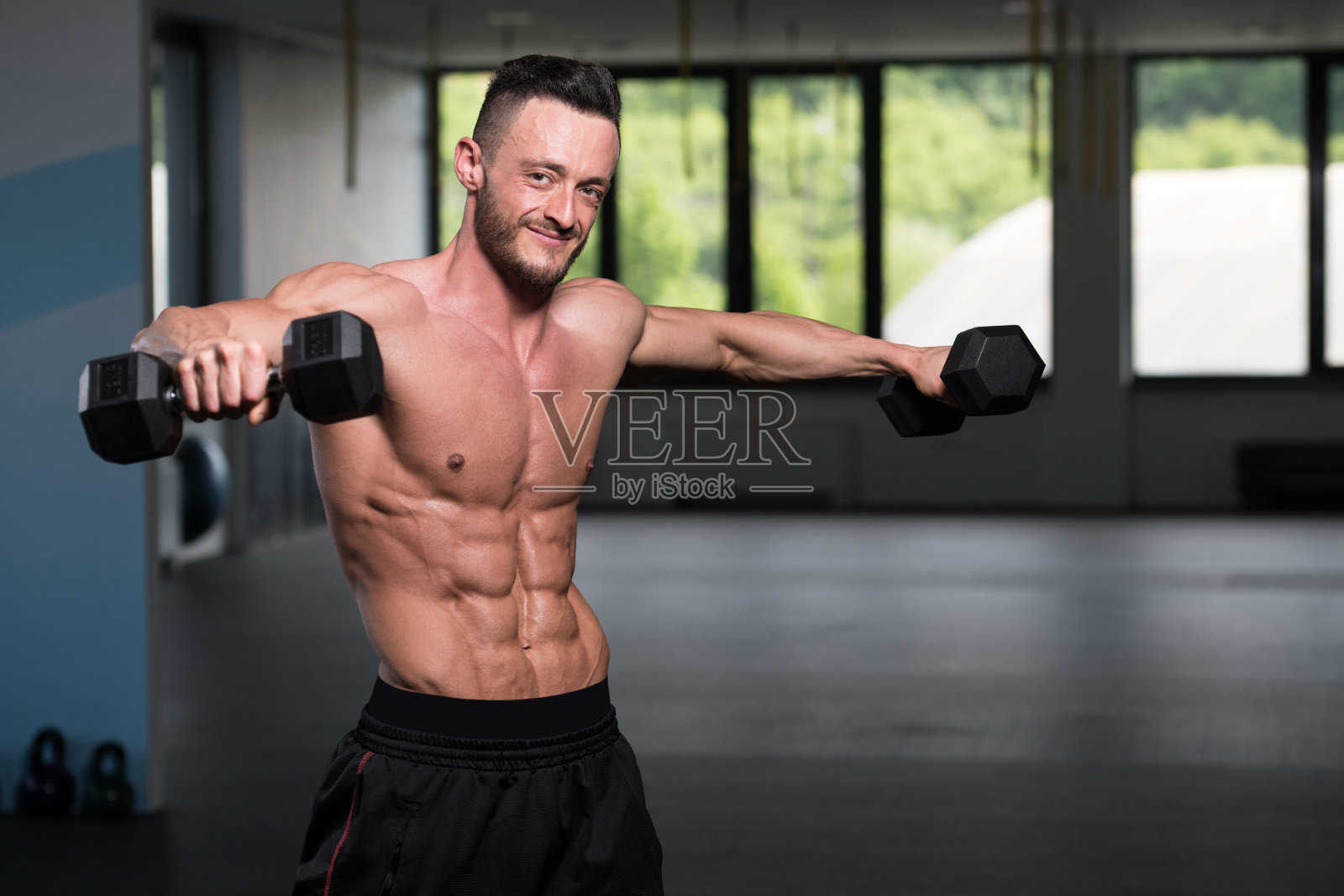 用哑铃锻炼肩膀的人照片摄影图片