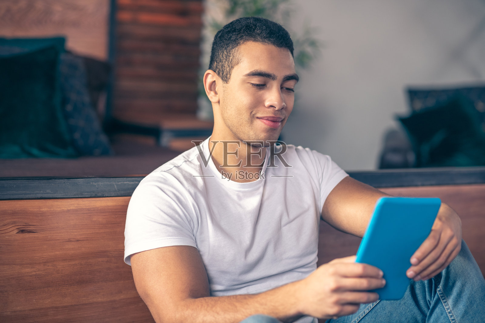 床边有个人,手里拿着平板电脑。照片摄影图片