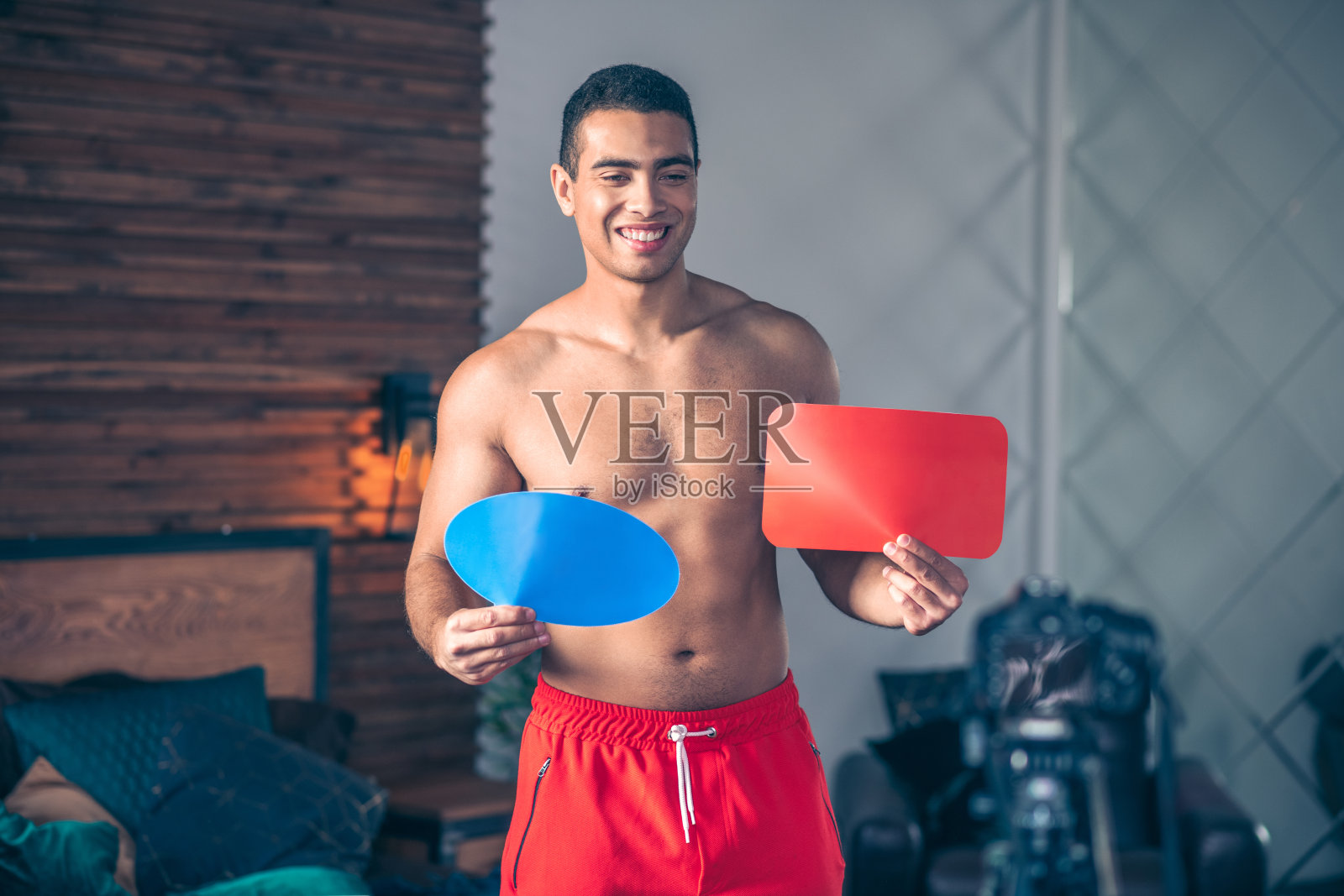 年轻的健身视频博主在红色短裤看起来很开心照片摄影图片