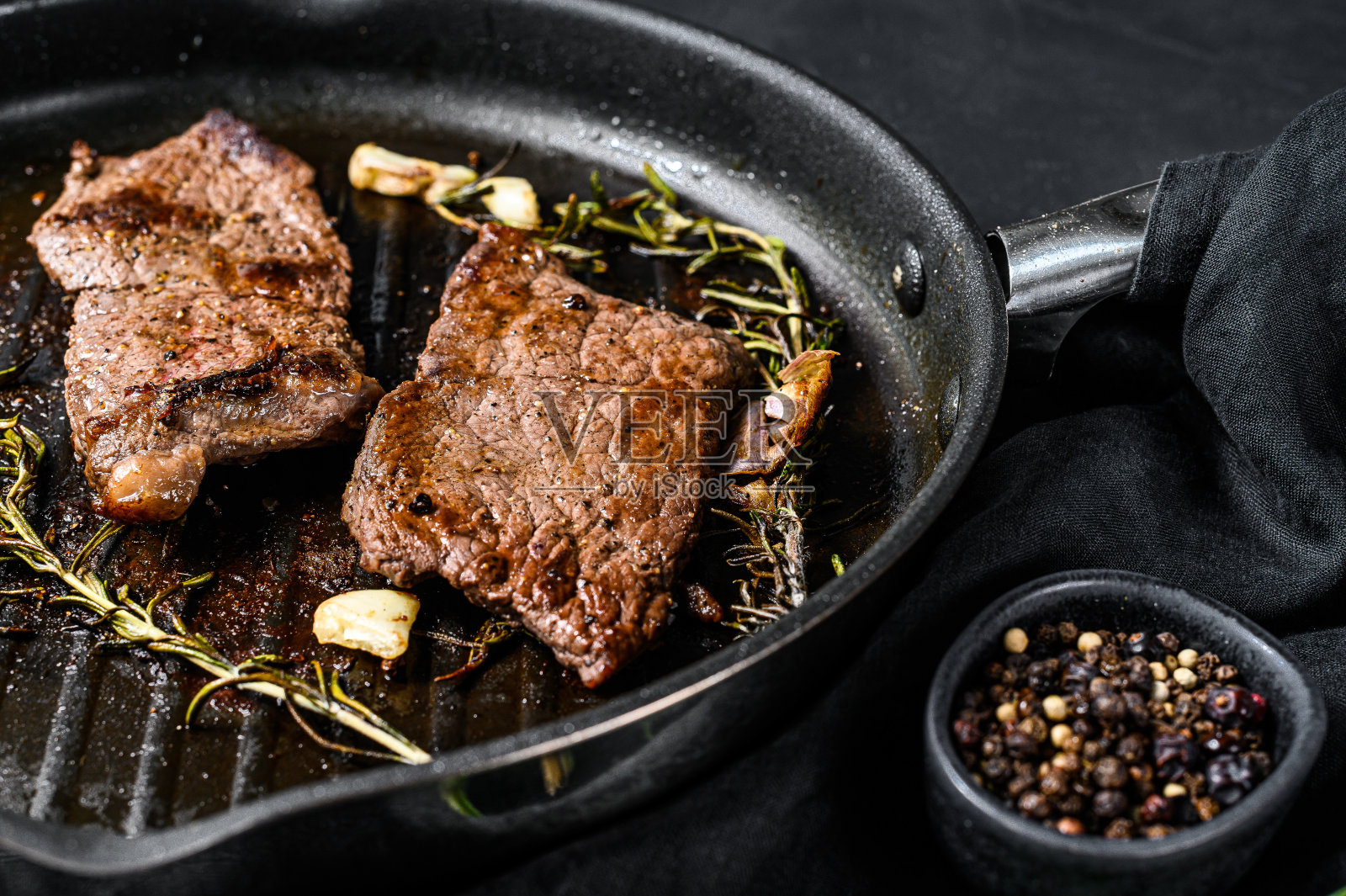 煎锅里的西冷牛排。烤的肉。黑色背景。俯视图照片摄影图片