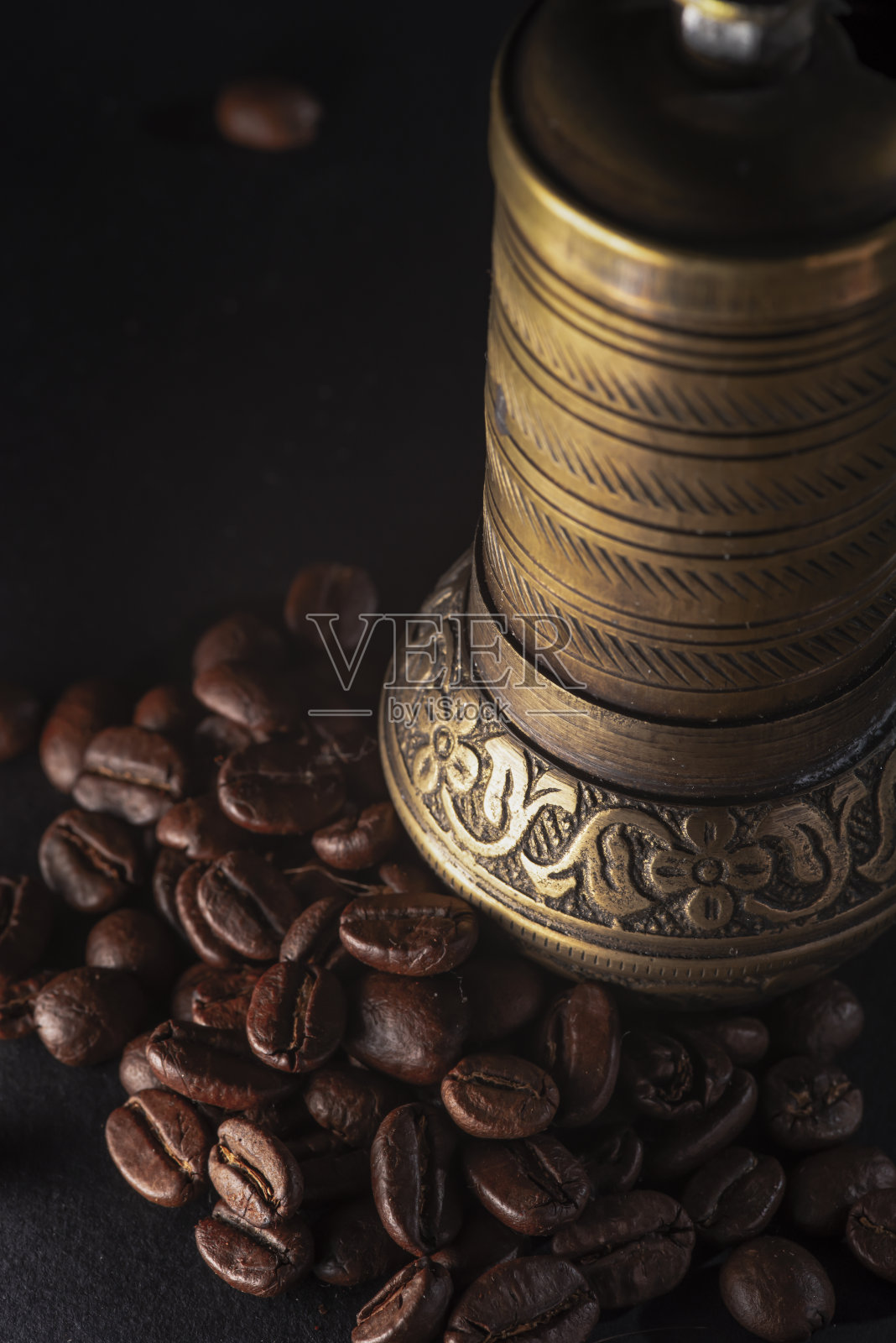 黄铜咖啡研磨机与烤咖啡豆。孤立在黑色背景上。照片摄影图片