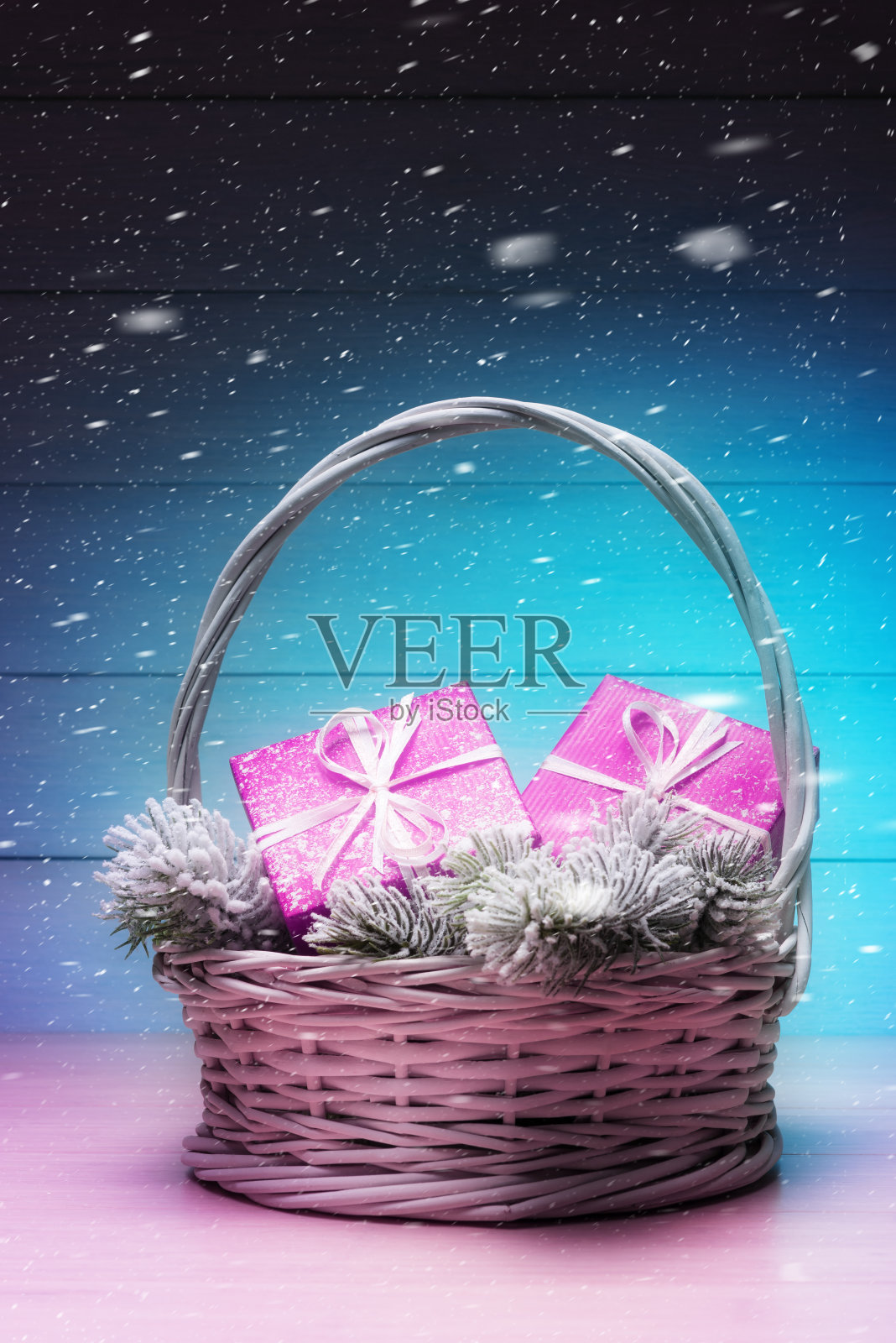 新年贺卡和粉红色礼盒的篮子,霜冻云杉树枝在下雪的背景照片摄影图片