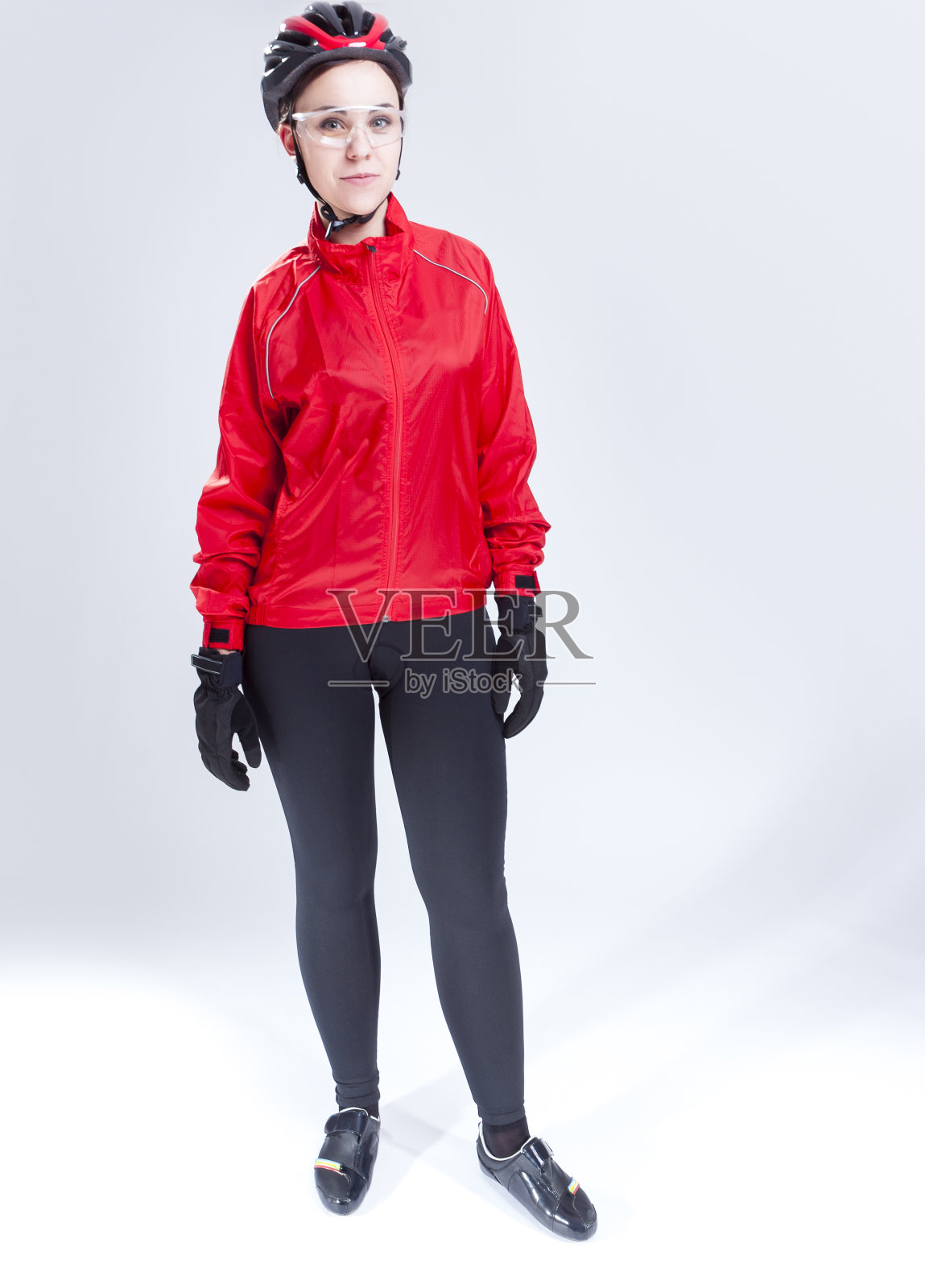 运动概念和想法。肖像的白人女自行车运动员摆姿势装备在工作室的专业服装。垂直的图像照片摄影图片