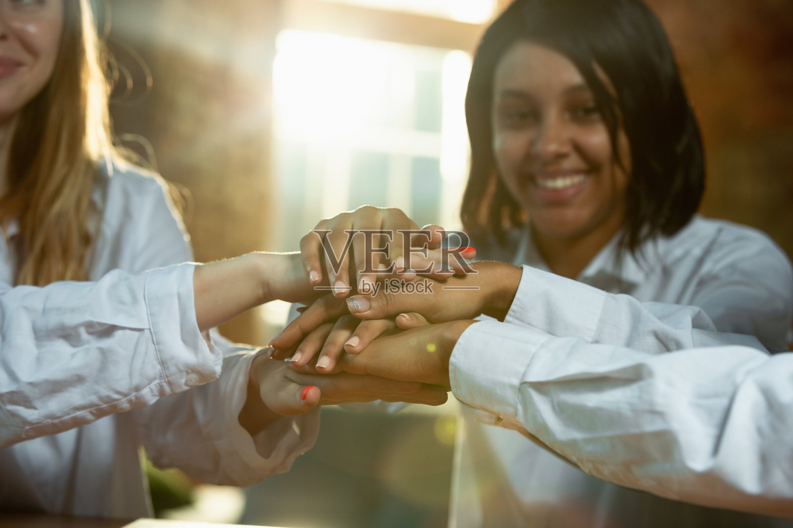 近距离的非洲裔美国人和白人人类的手握在木桌上照片摄影图片