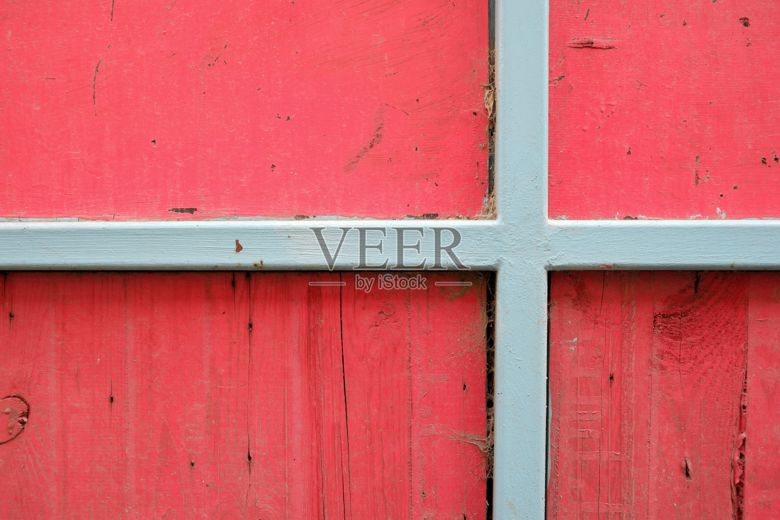 灰色的铁架在红色的木栅栏上。照片摄影图片