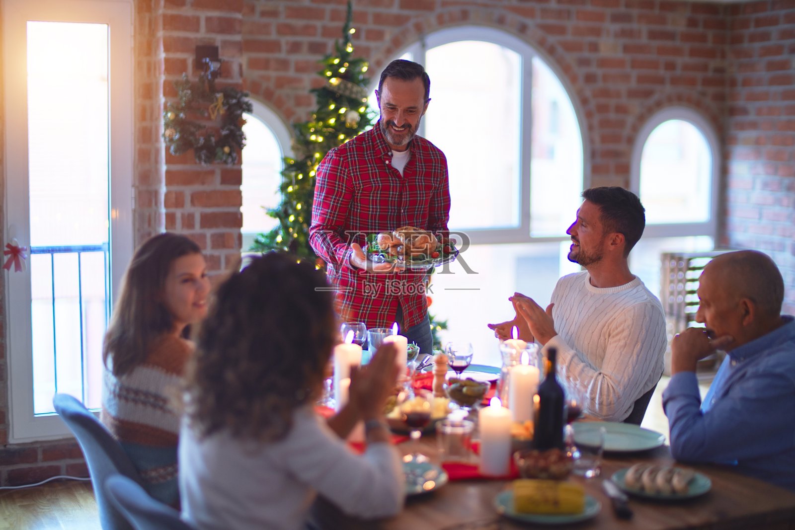 美丽的家庭微笑幸福自信。展示烤火鸡,在家里鼓掌庆祝圣诞节照片摄影图片