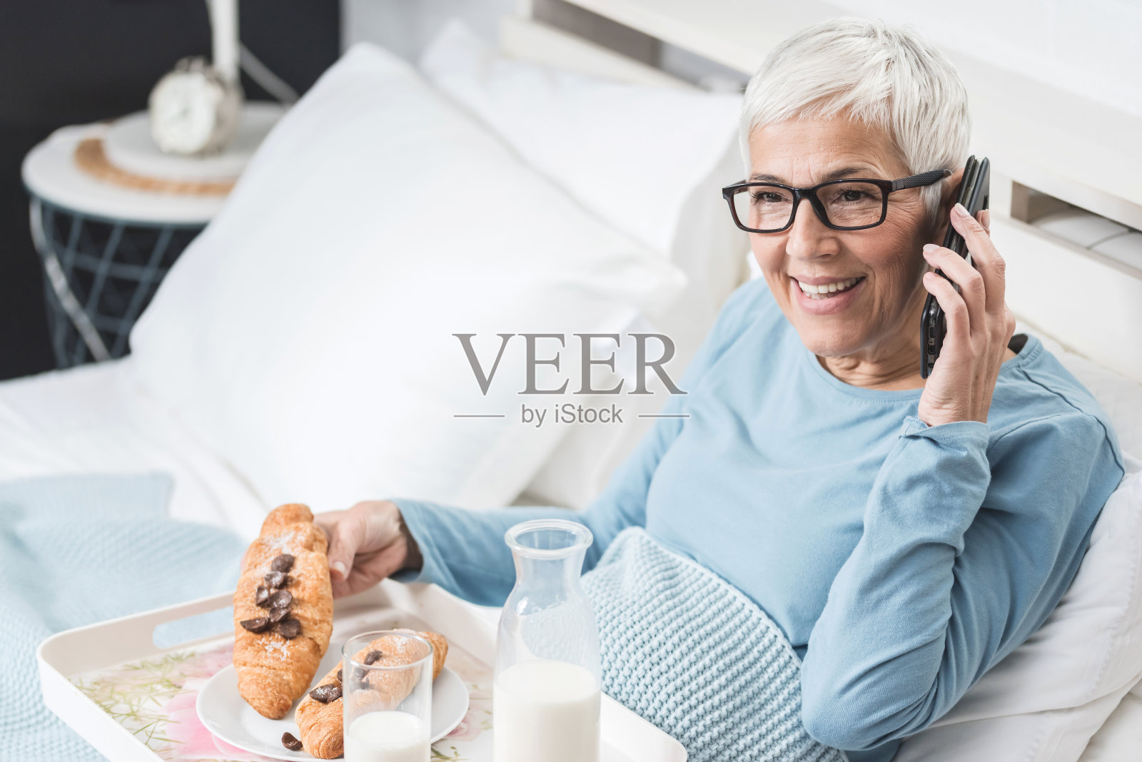 老女人在床上吃早餐照片摄影图片