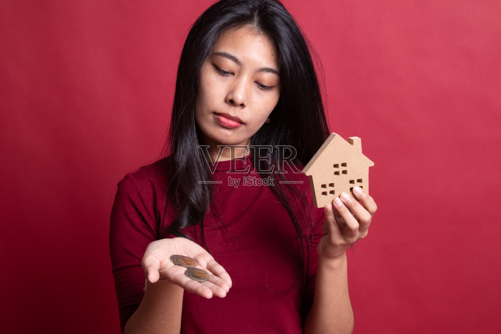 年轻的亚洲女人有房子模型和硬币。照片摄影图片