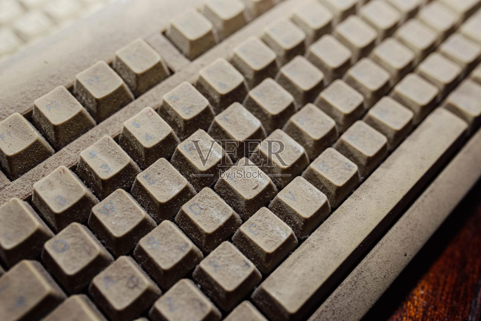 尘土飞扬的电脑键盘。过时的技术概念。照片摄影图片