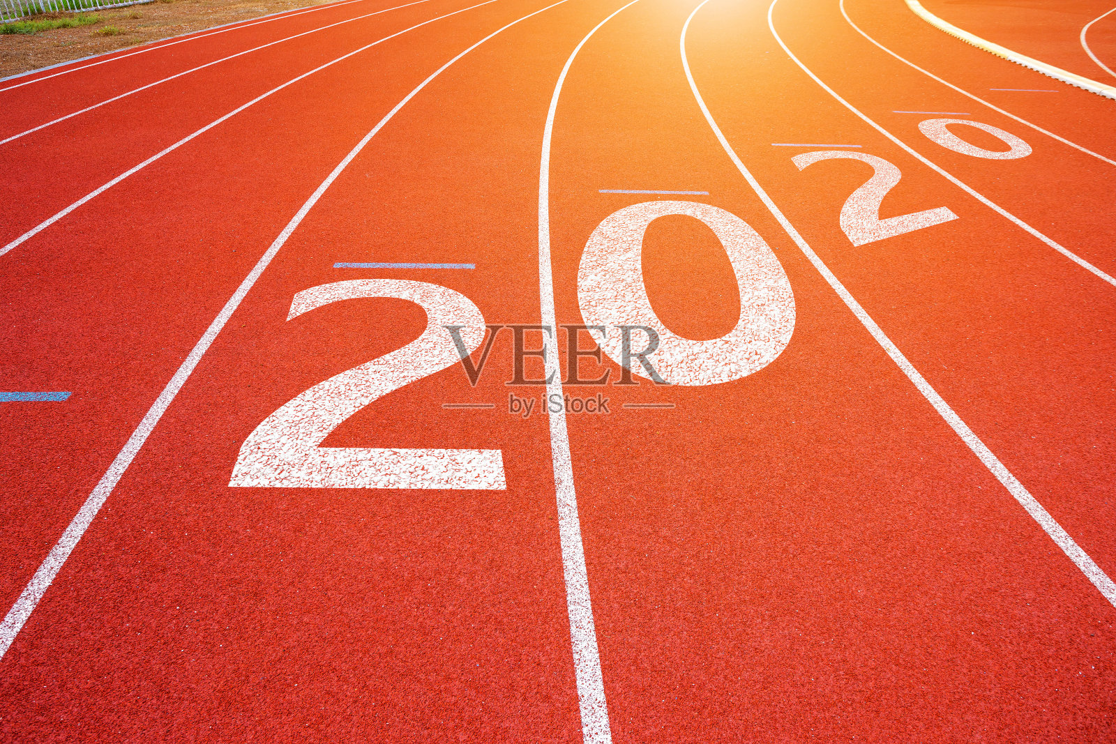 体育场的白色线条和跑步跑道的纹理红色橡胶跑道与2020年新年快乐的文字,在圣诞和新年。照片摄影图片
