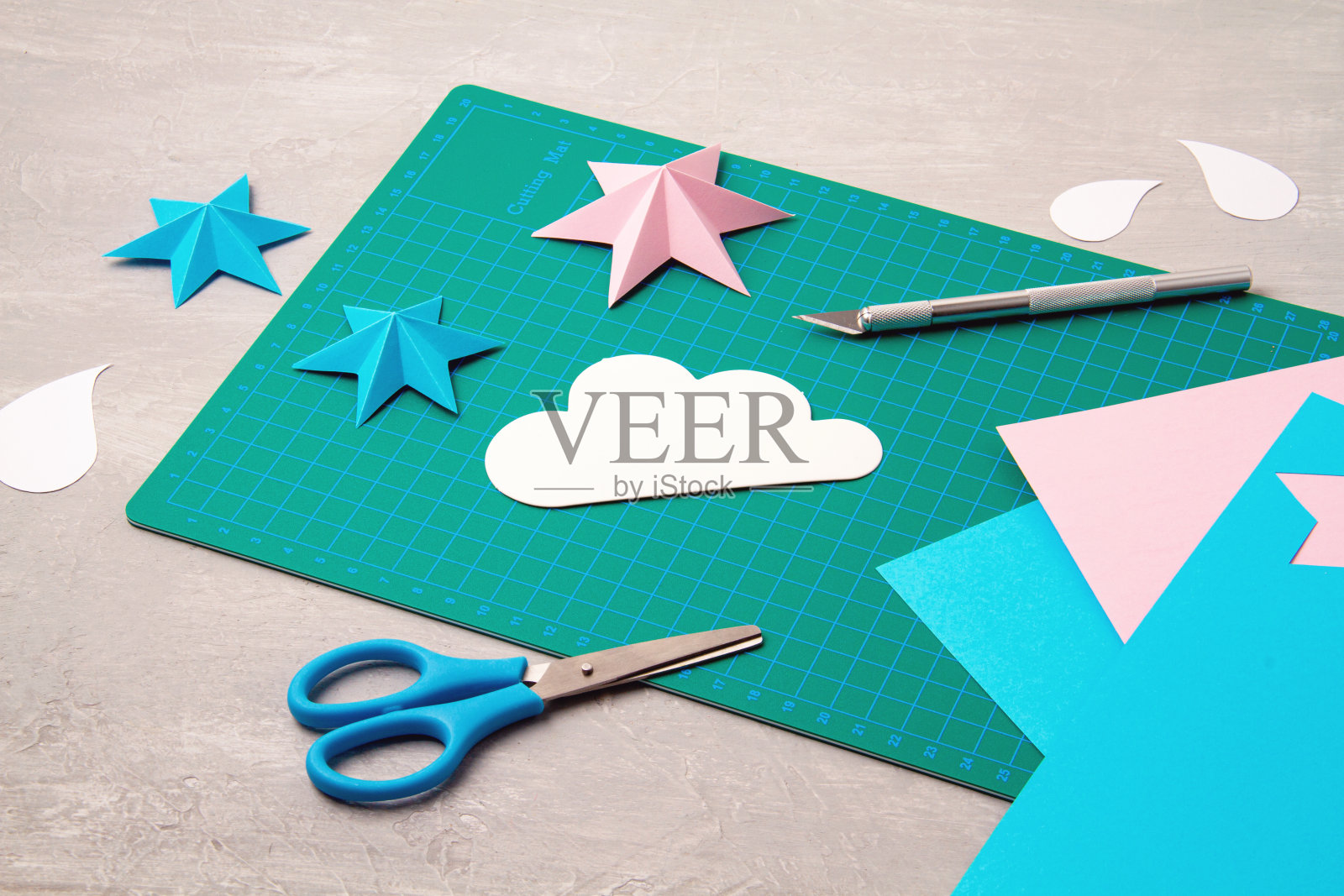 俯视图超过剪纸工具,剪刀,刀具,切割垫,和精心制作的纸对象。DIY新潮项目概念照片摄影图片