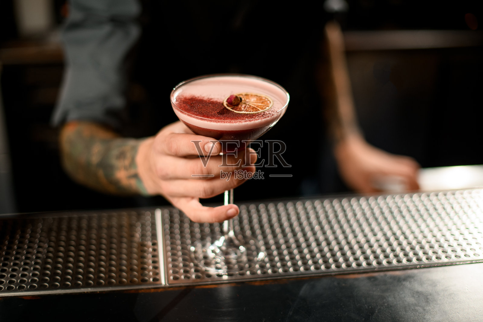 酒保拿着一杯非常美味的鸡尾酒照片摄影图片