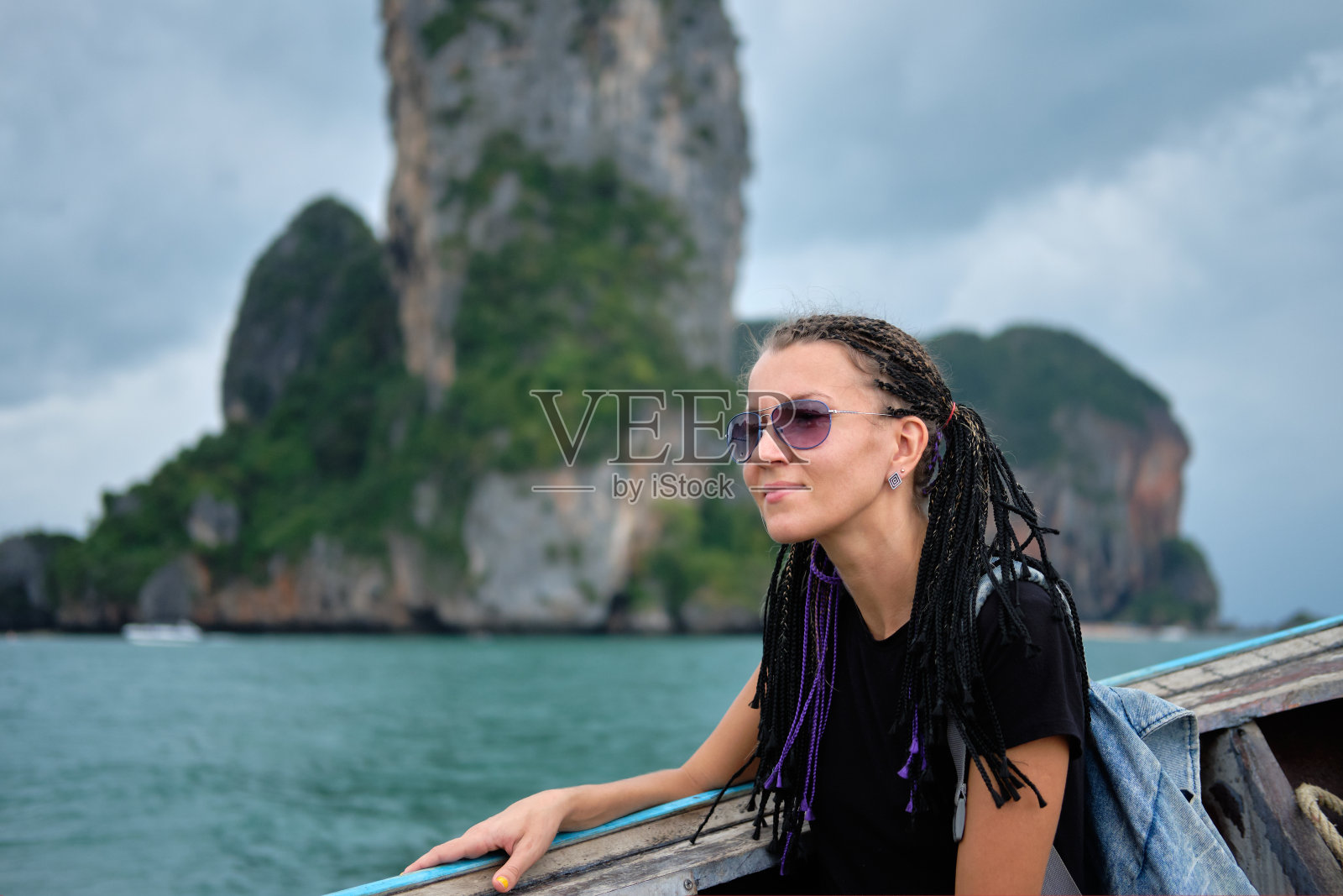 年轻女子坐在长尾的士船上,观赏泰国的海景照片摄影图片