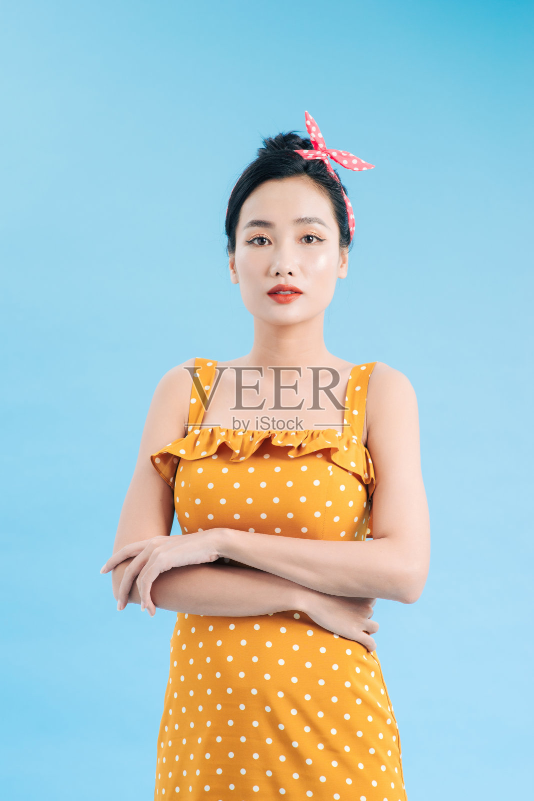 穿着黄色圆点连衣裙的年轻女子照片摄影图片