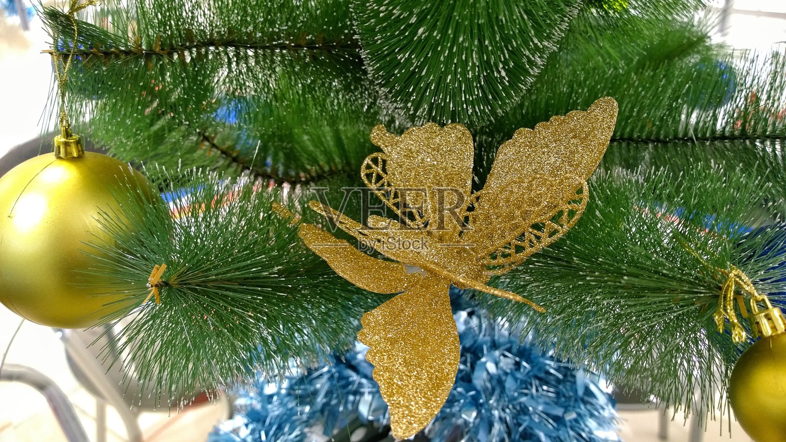 新年快乐背景:金色蝴蝶和闪亮球圣诞树装饰照片摄影图片