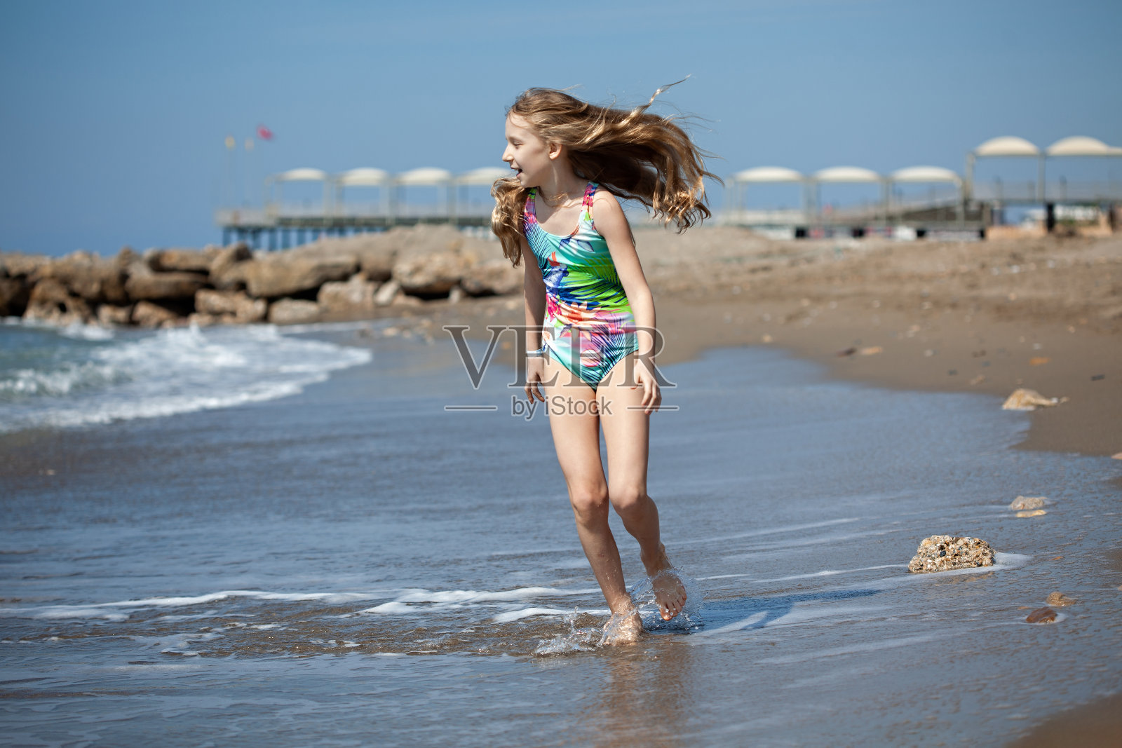 一个白人女孩在海滩上跑步照片摄影图片