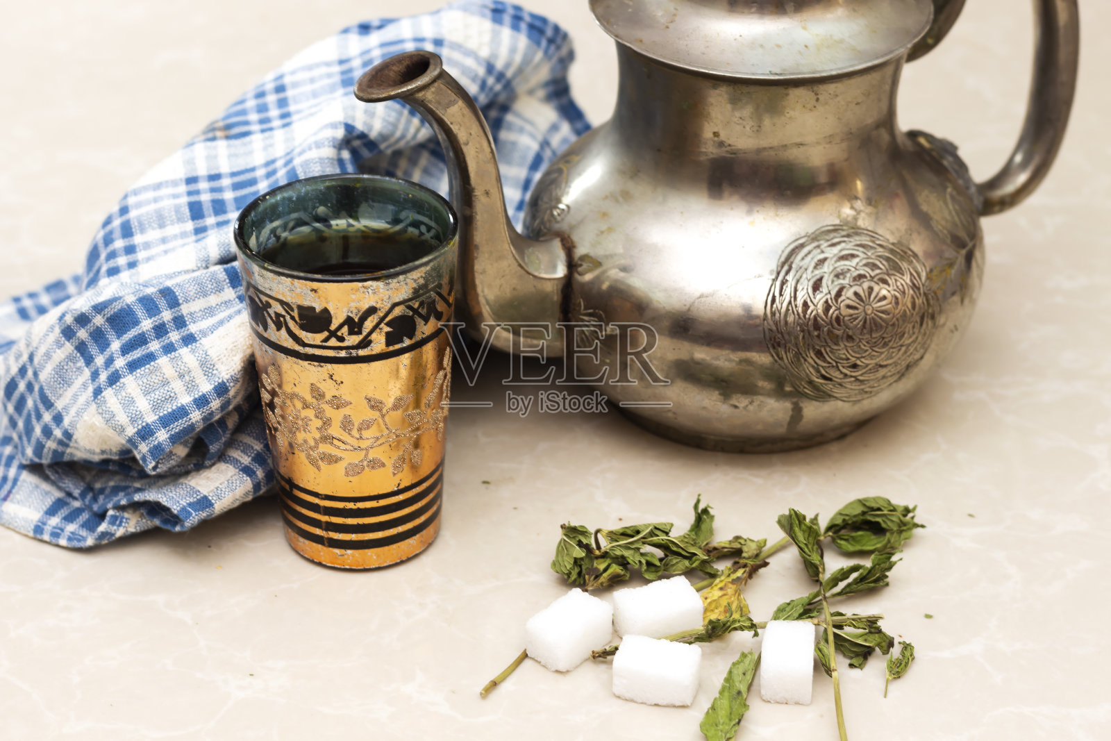 阿拉伯古董银茶壶和玻璃杯,干薄荷和方糖照片摄影图片