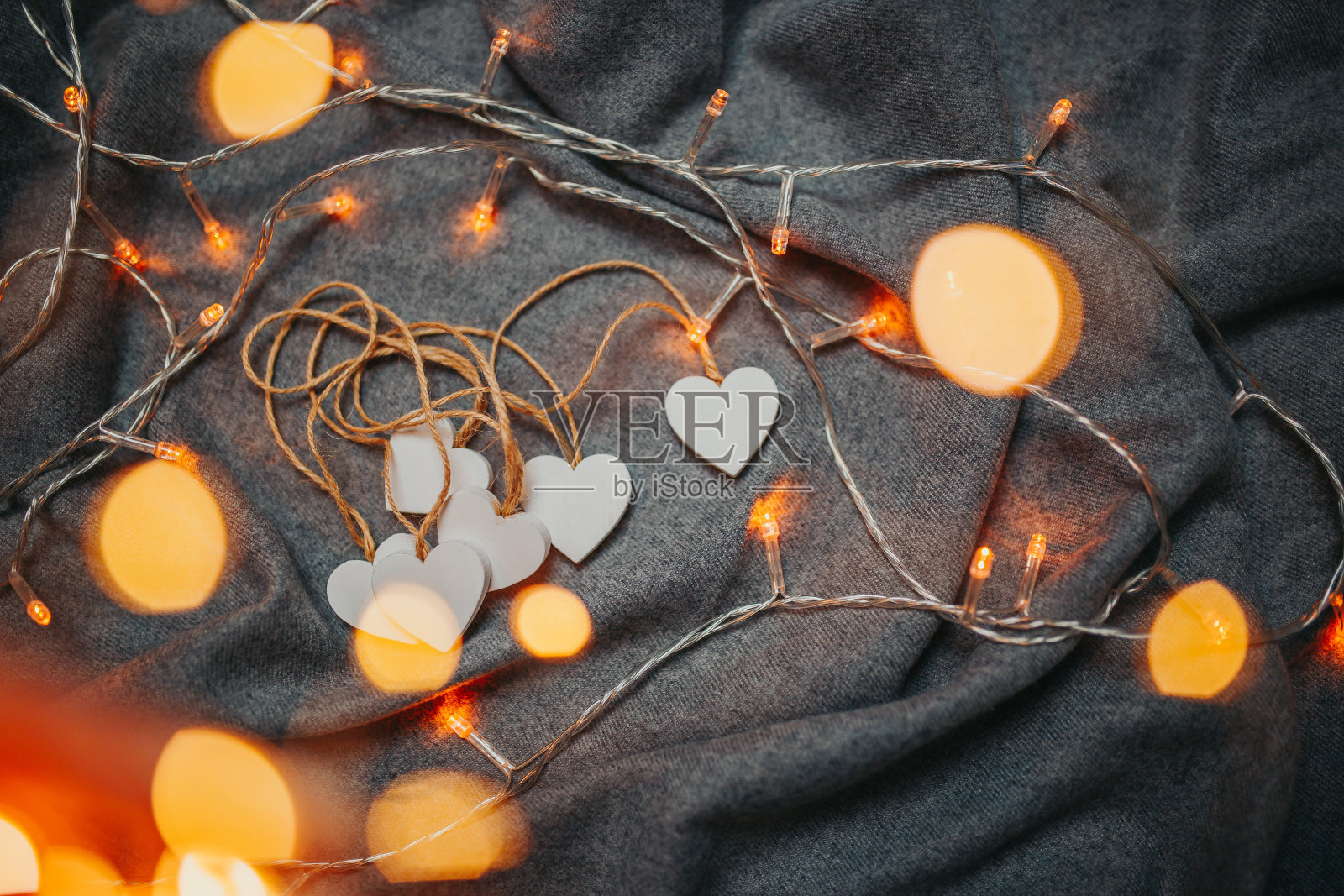 情人节卡片。灰色背景上的白色木心。心与花环的光芒。照片摄影图片