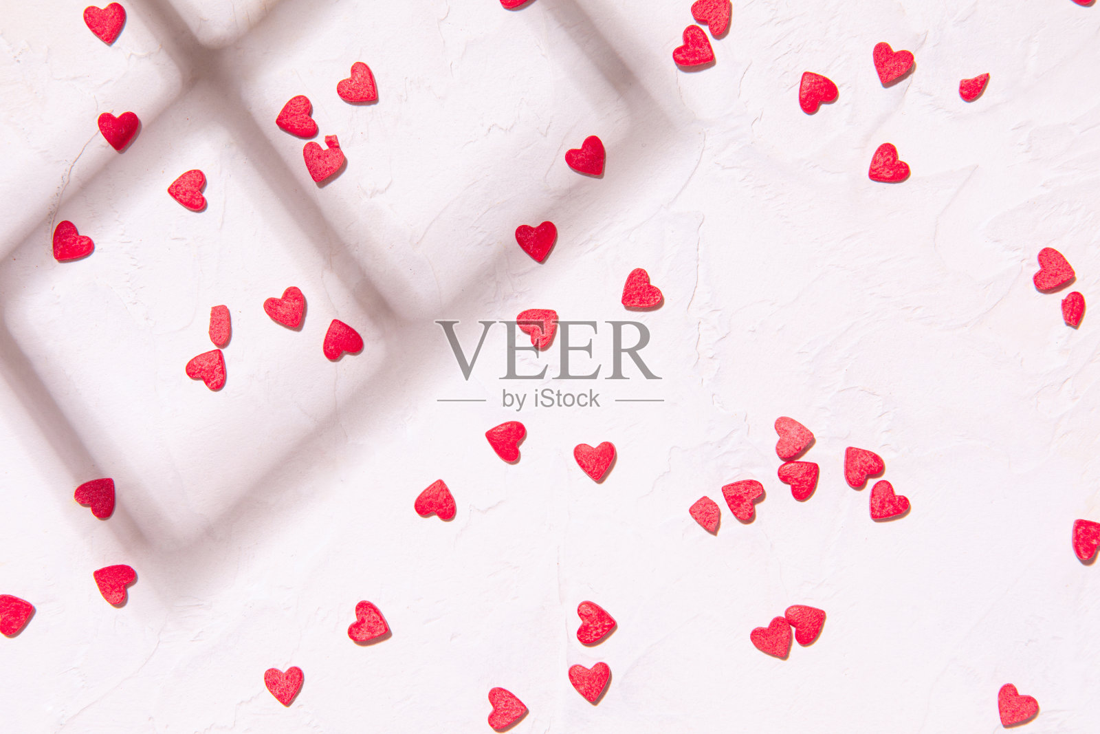 粉色心形纸屑在白色木质背景上的时尚风格。红心,情人节贺卡照片摄影图片