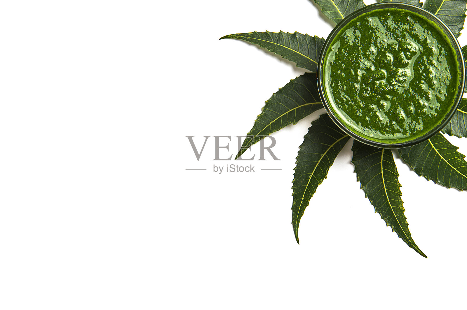 白色背景下碗中带有浆糊的药用印楝树叶照片摄影图片