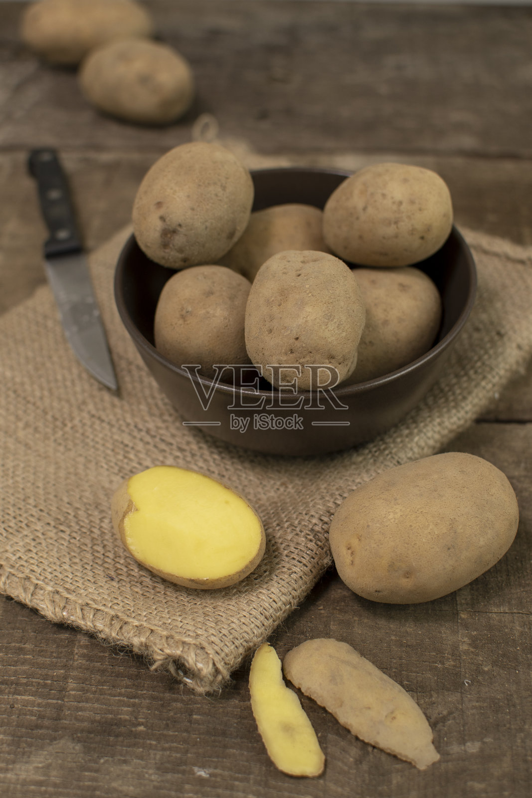 新鲜的土豆放在木桌上的碗里照片摄影图片