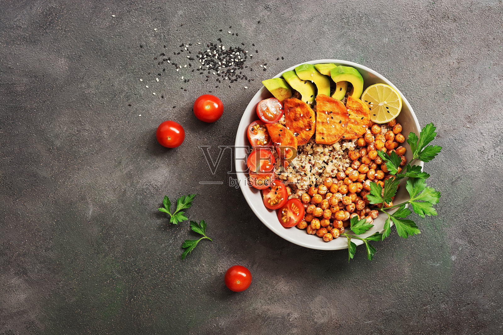 一碗健康沙拉,炸鹰嘴豆,炸红薯,鳄梨,藜麦,西红柿和绿色蔬菜。俯视图,平放。照片摄影图片