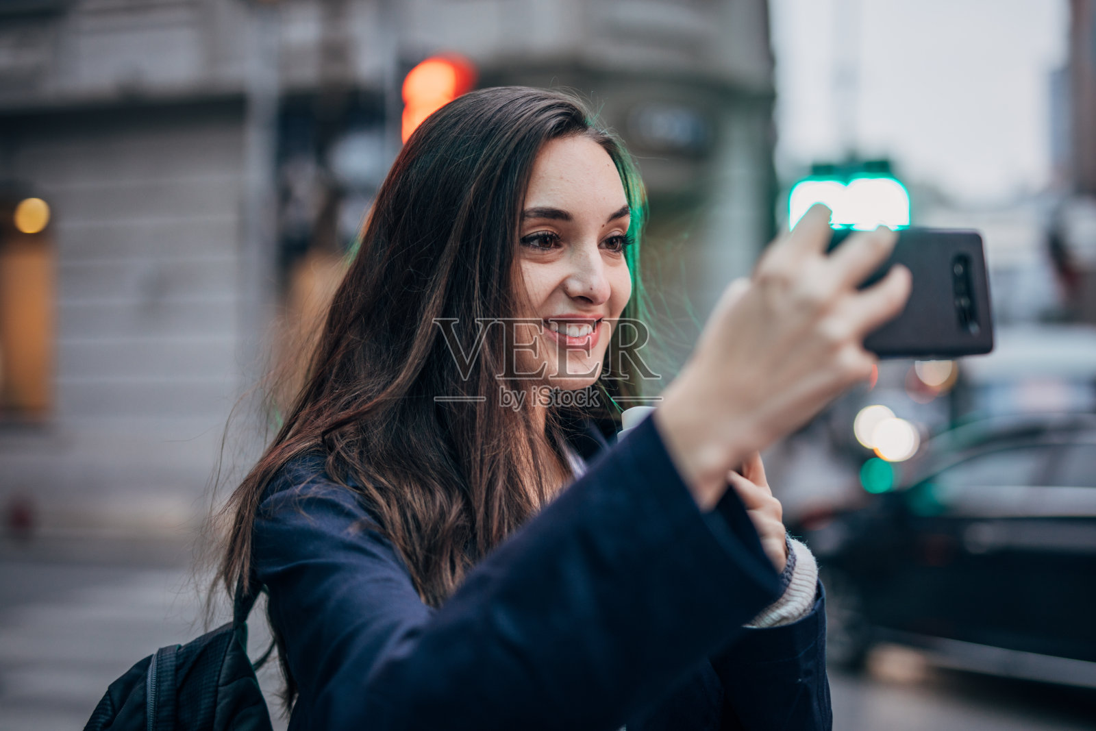 年轻女人用智能手机自拍并拿着一杯咖啡照片摄影图片