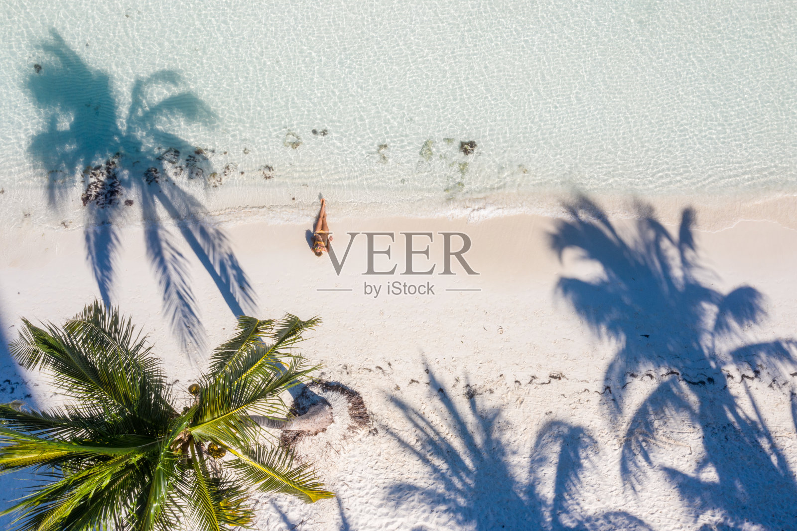 棕榈树白沙滩上女子放松身姿无人机航拍视角照片摄影图片