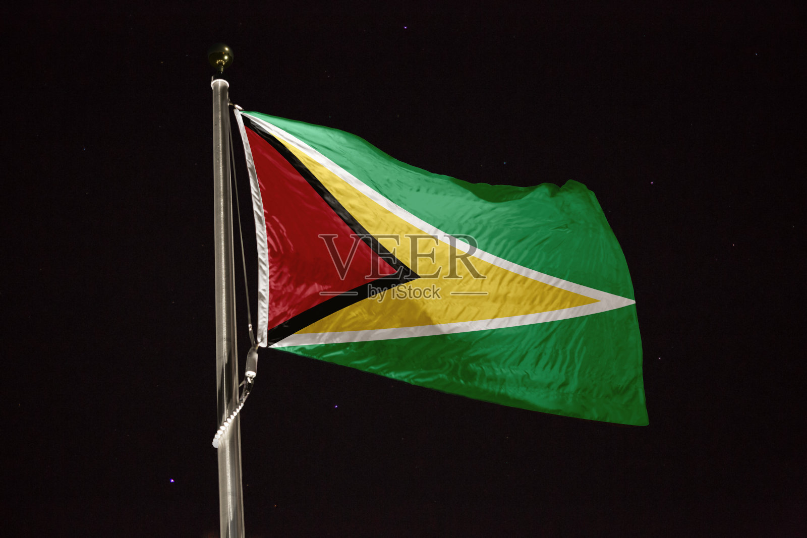 圭亚那的旗帜在夜晚的风中飘扬照片摄影图片