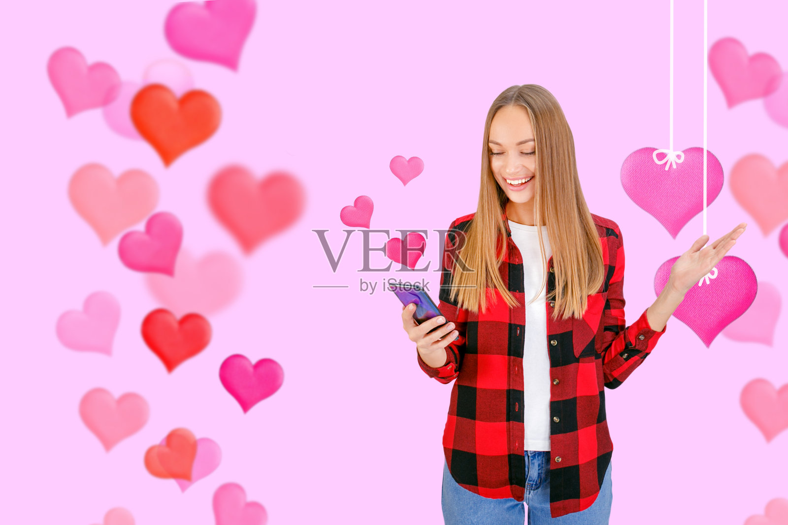 手持手机和情人节爱心的年轻时尚模特照片摄影图片