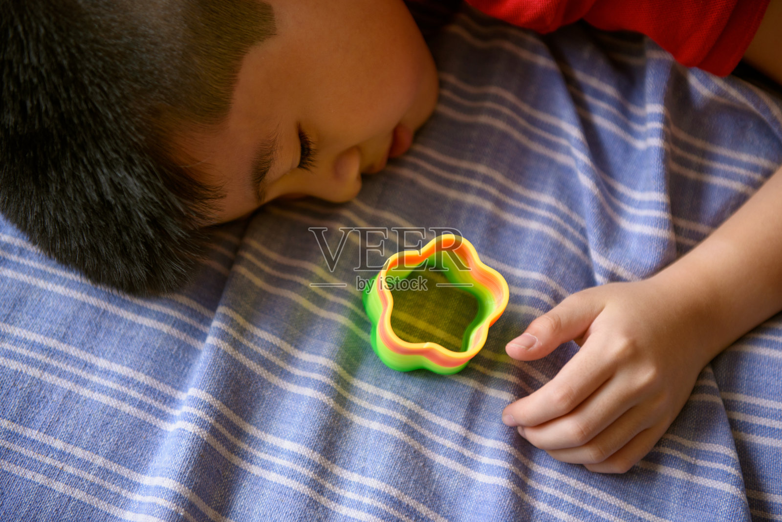 亚洲男孩玩花形弹簧彩虹照片摄影图片