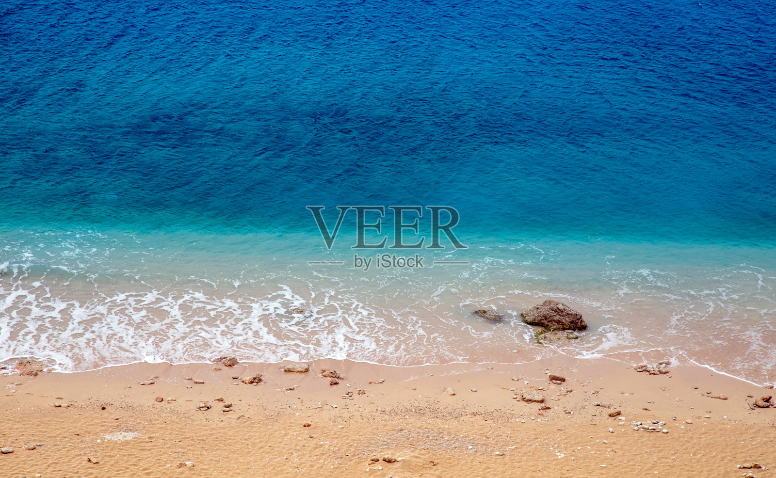 绿松石色的大海和海滩上的石头。照片摄影图片