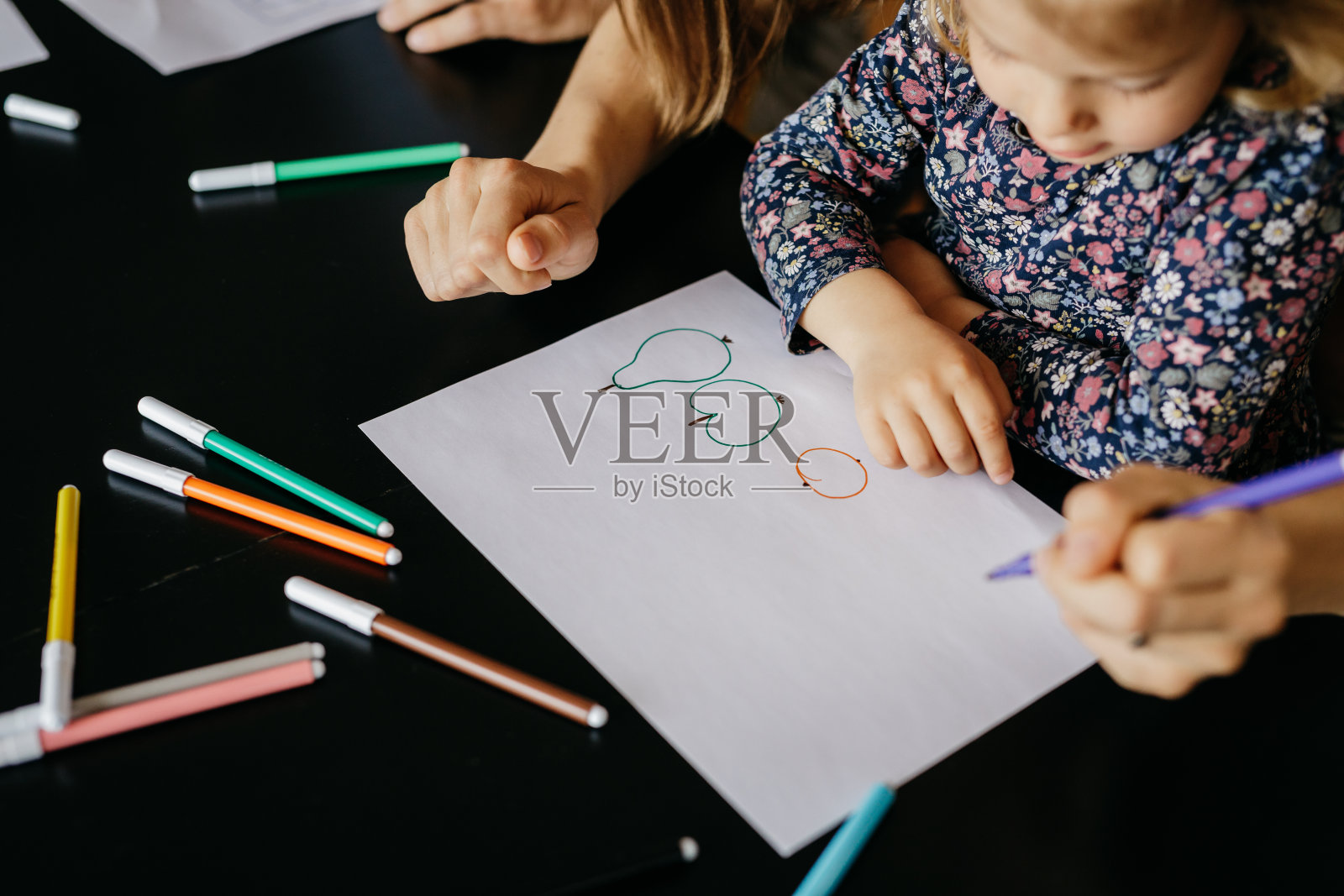 一个孩子的手和他的绘画和着色与马克笔的特写照片摄影图片