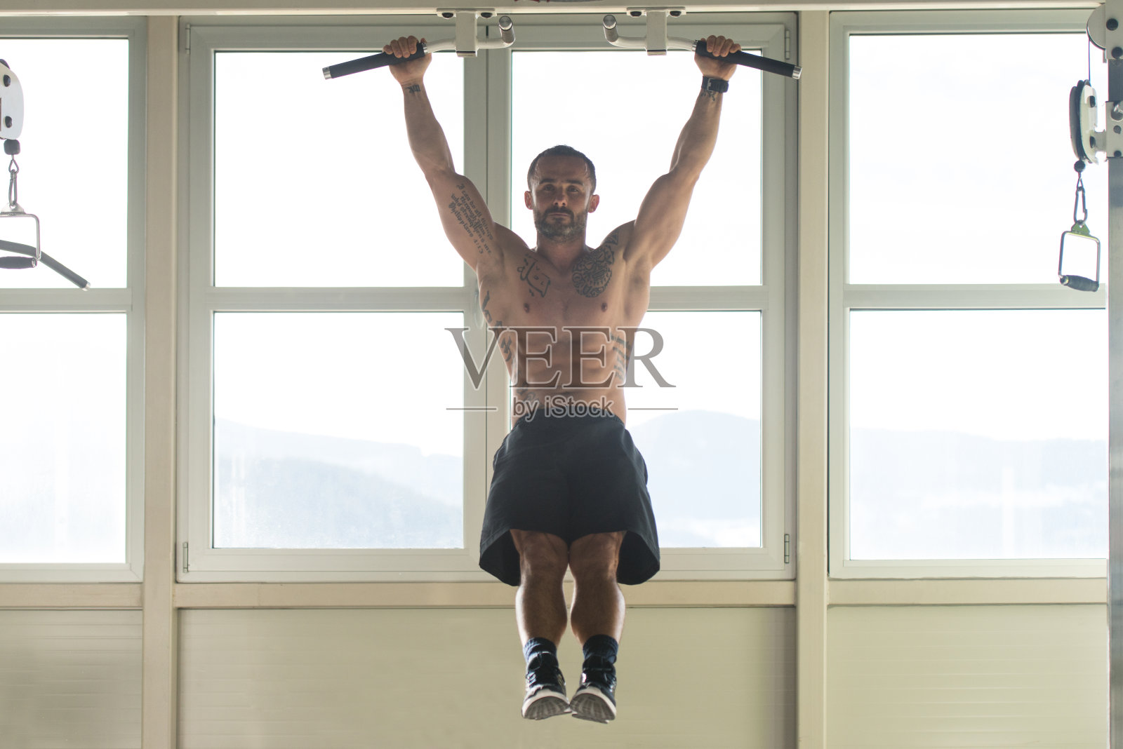 男人做悬垂抬腿运动照片摄影图片