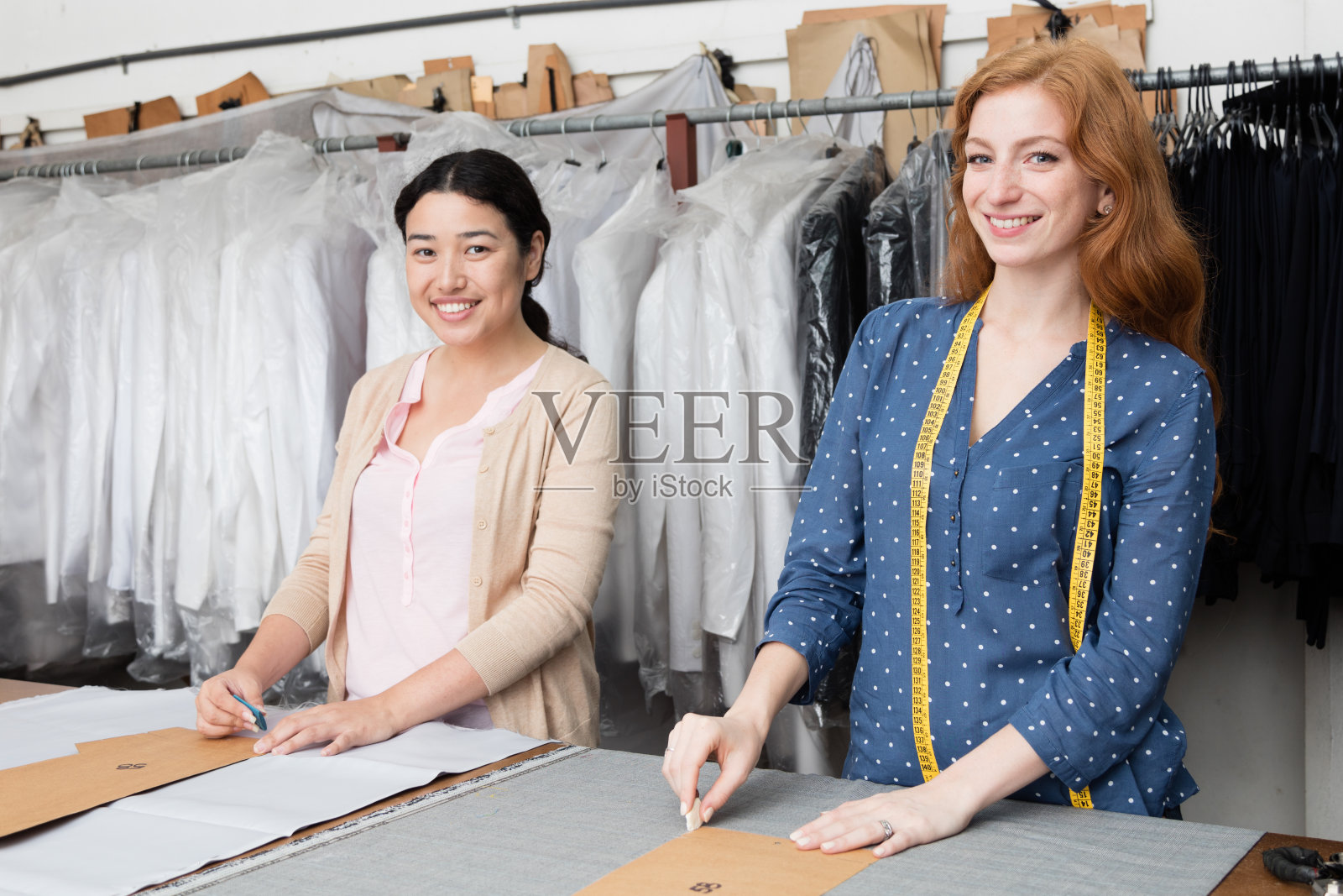 在缝纫工作室里微笑的年轻设计师肖像照片摄影图片