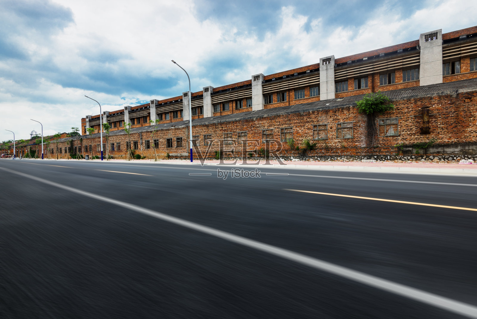 老工业区外笔直向前延伸的柏油路。照片摄影图片