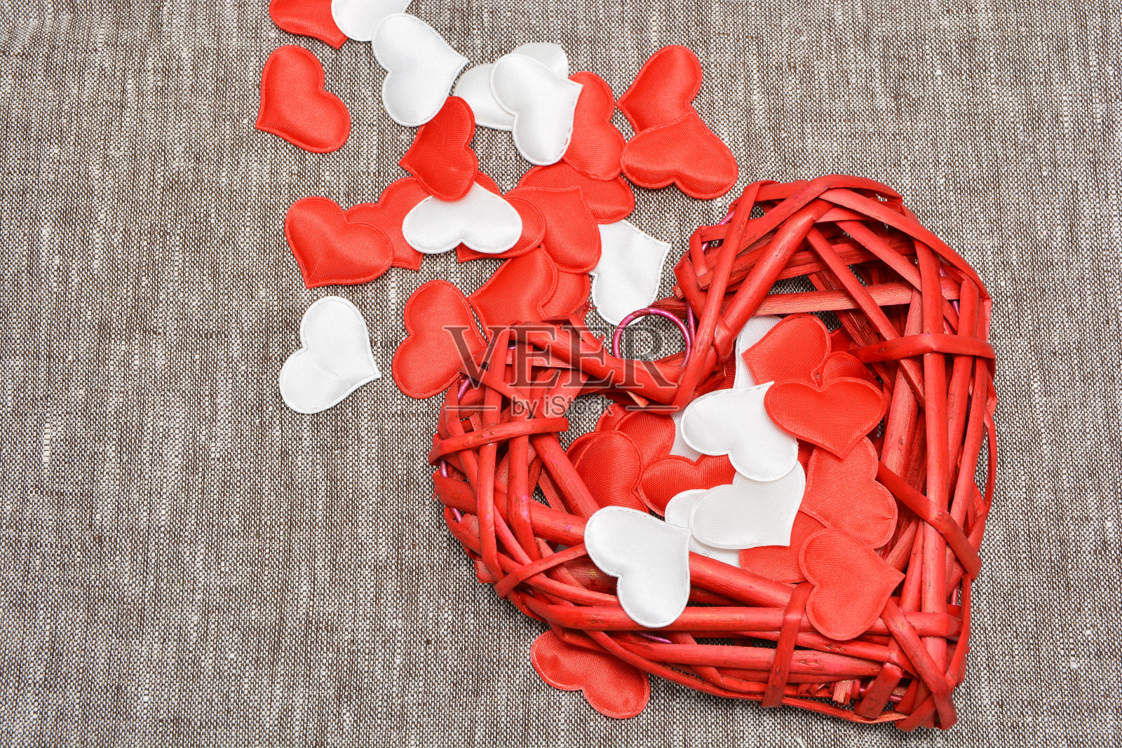 红织了一颗大心和一颗小心,用丝织在亚麻布地上。主题为情人节和节假日照片摄影图片
