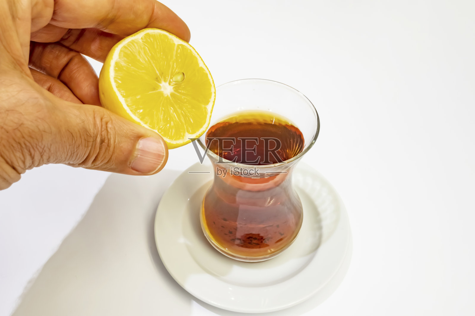 手里拿着半个柠檬和土耳其茶照片摄影图片