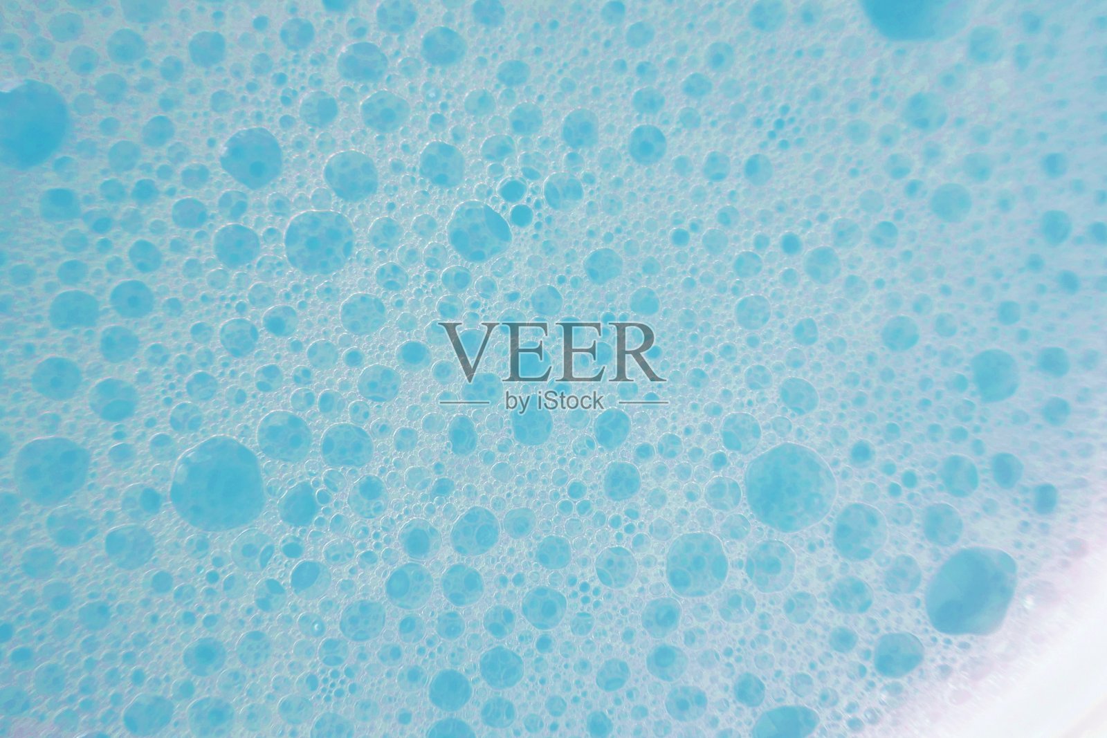 蓝色肥皂泡沫宏背景。肥皂泡蓝色柔和的颜色。洗涤剂纹理。纯洁和新鲜。沐浴液。缓解。明度和空气流通照片摄影图片