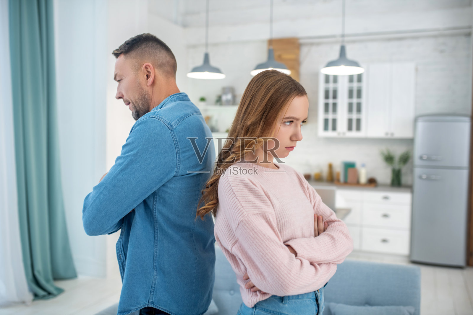 父女背靠背站着,双臂交叉。照片摄影图片