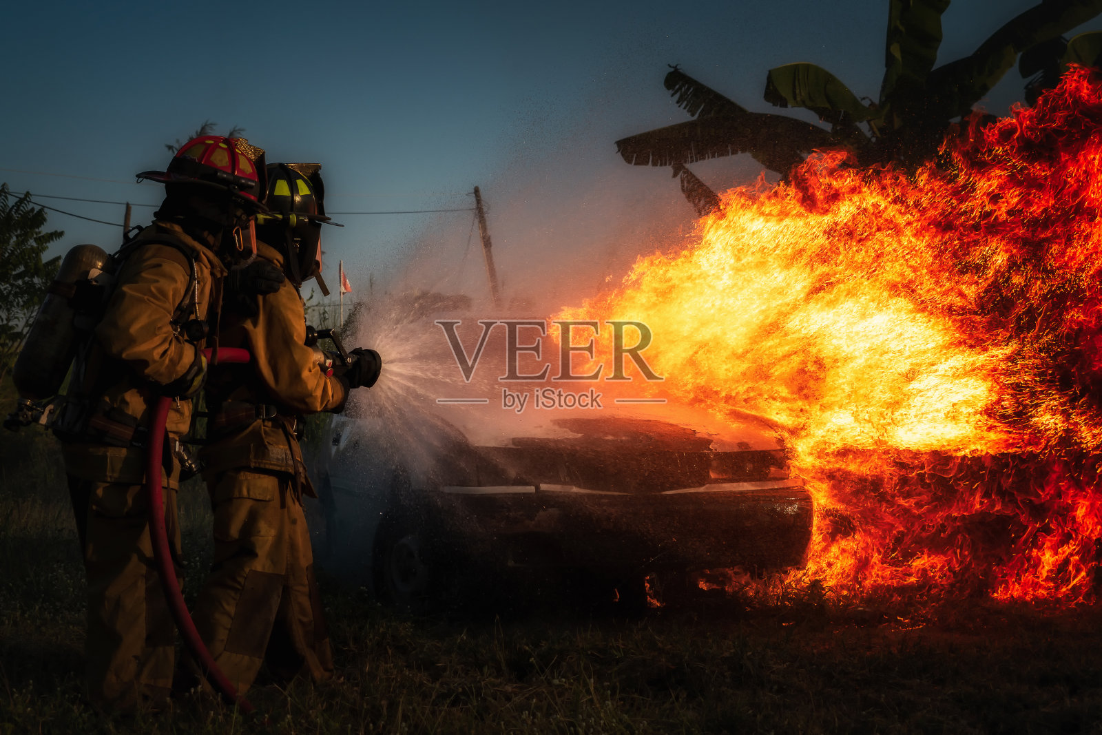 消防员试图扑灭汽车。照片摄影图片