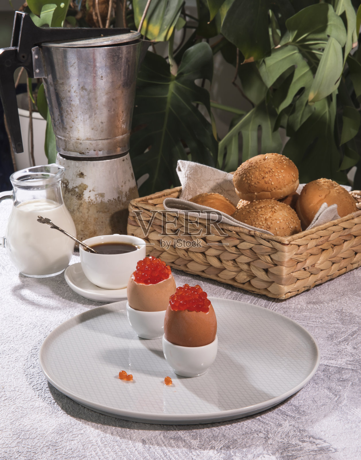 早餐。摊位上塞满红鱼子酱的鸡蛋,新鲜的芝麻面包,新煮的咖啡和一罐奶油。照片摄影图片